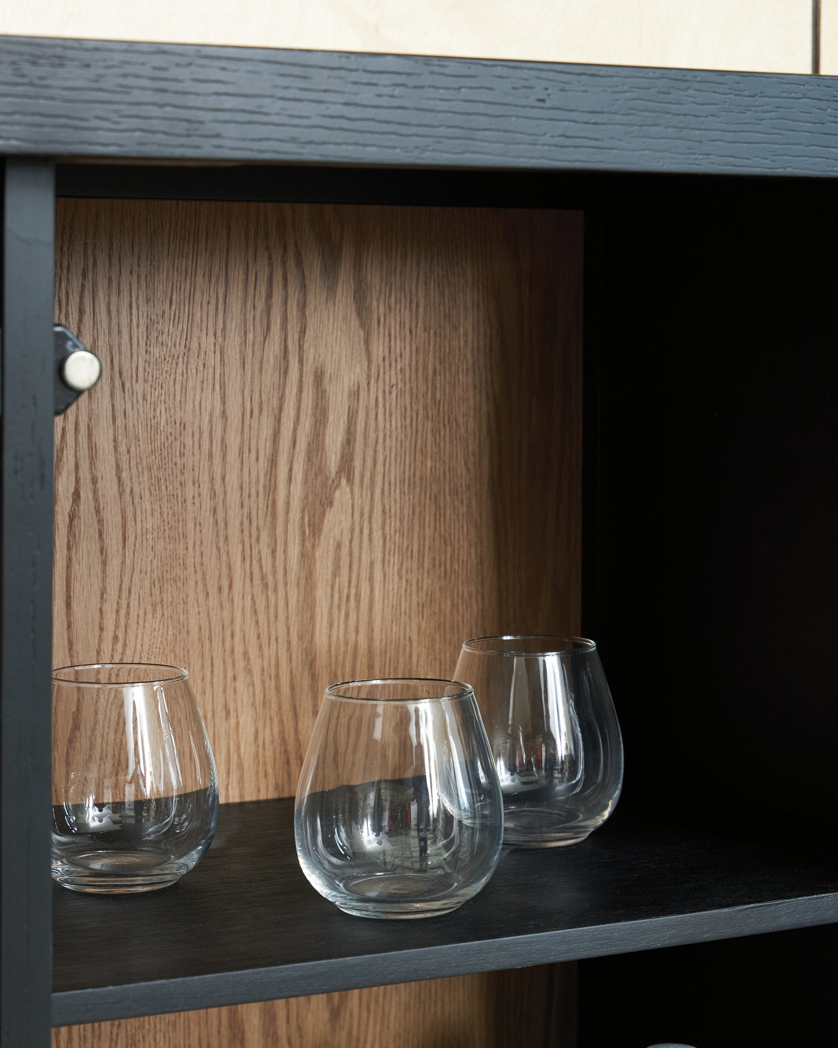 Close-up detail of cabinet door handle and wood finish