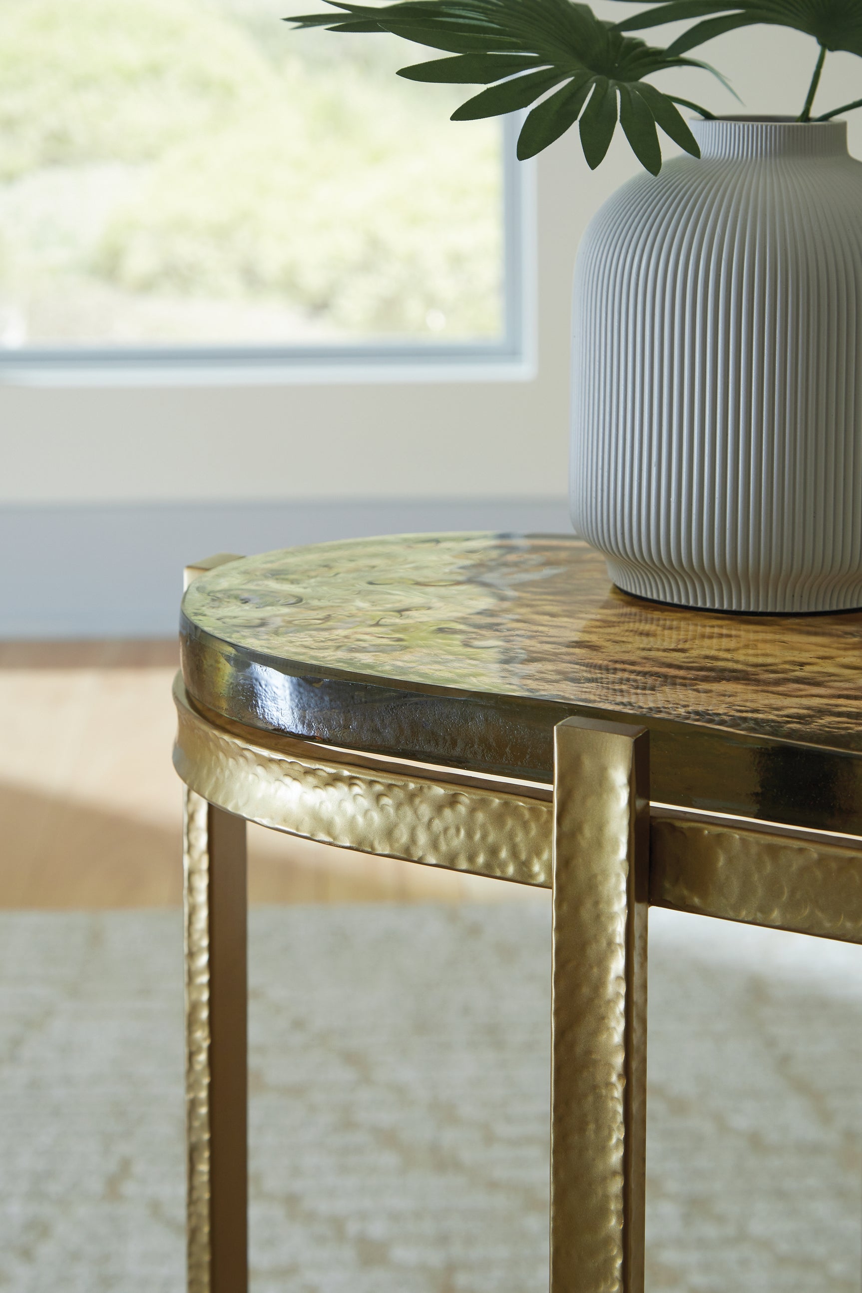 Detail of goldtone finish and cast glass top on Porterville accent table