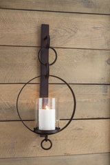 Ogaleesha Wall Sconce mounted on wall with pillar candle inside glass shade