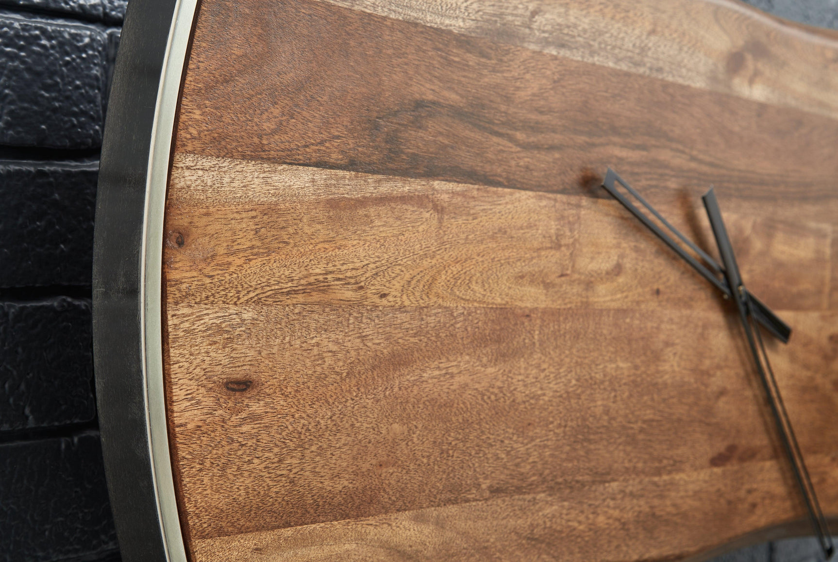 Detail view of Panchali wall clock metal trim and wood finish