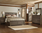 Close-up of Juararo bed footboard with rustic finish and pewter hardware