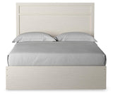 Side view of Stelsie White Queen Panel Bed highlighting storage drawers