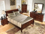 Close-up of dark brown finish and carved details on bed