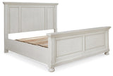 Nightstand beside Robbinsdale Antique White King Panel Bed in styled bedroom
