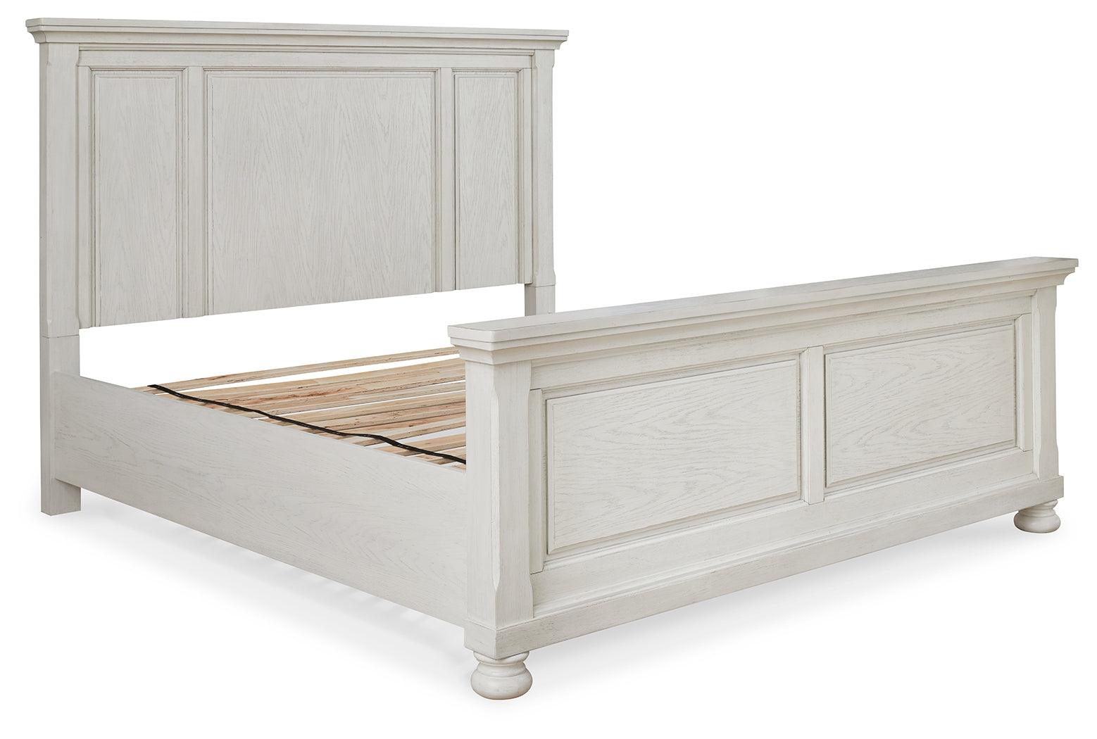 Nightstand beside Robbinsdale Antique White King Panel Bed in styled bedroom