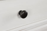 Close-up of pewter-tone round knob hardware on chest of drawers