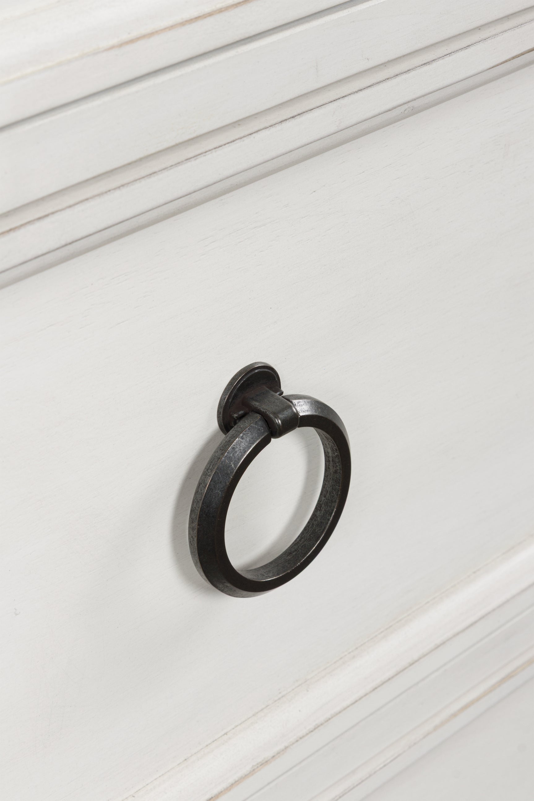 Close-up of pewter-tone ring pull hardware on chest of drawers