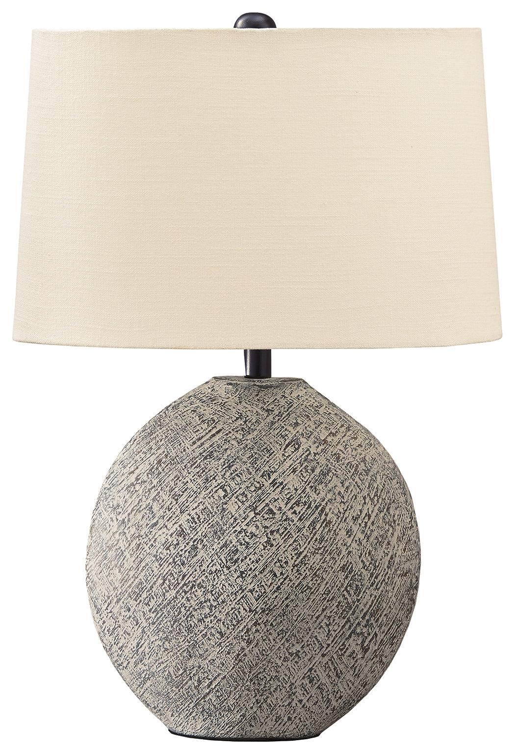 Harif Beige Table Lamp lit on bedside table