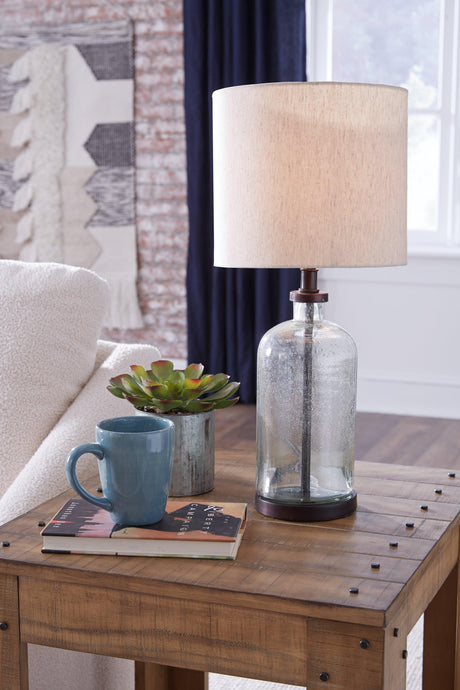 Bandile table lamp illuminated showing clear glass and bronze finish
