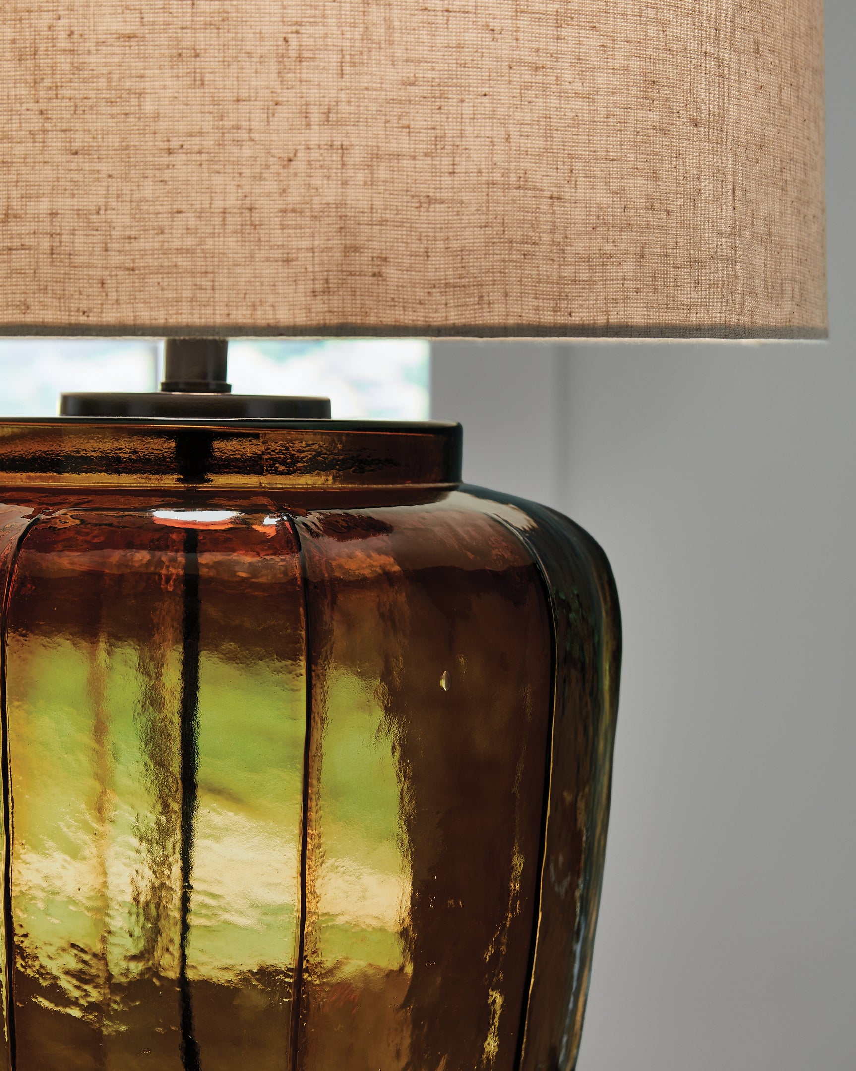 Close-up of the amber glass base and metal details on Bainmore lamp