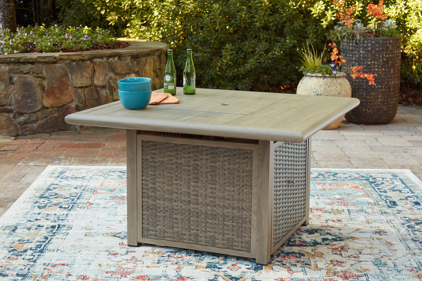 Outdoor fire pit table and chair set on patio