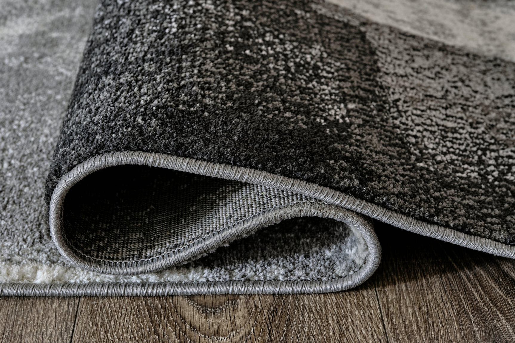 Brycebourne rug rolled showing jute backing and pile height