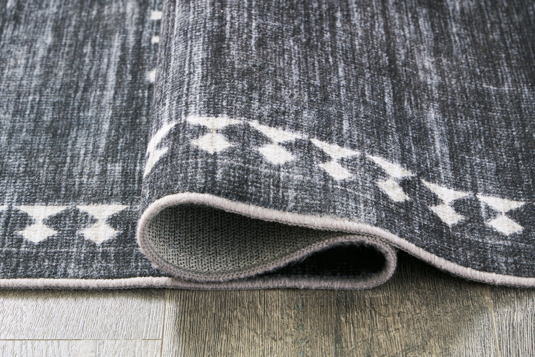 Rolled detail of Arloman black cream gray 5x7 rug