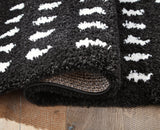 Rolled Minston black and white area rug showing texture
