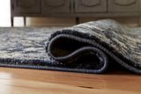 Hilcott rolled edge detail of blue cream brown rug