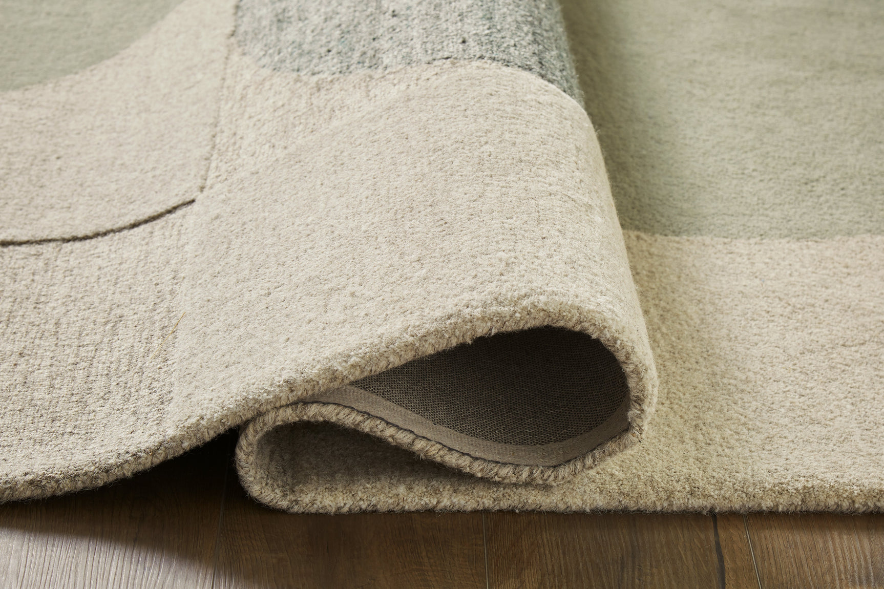 Rolled edge detail of Dallane blue green wool rug