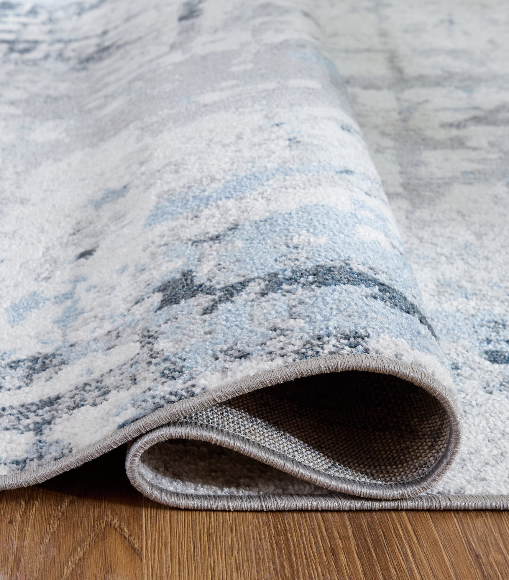 Rolled edge detail of Emertonly washable rug in blue white gray