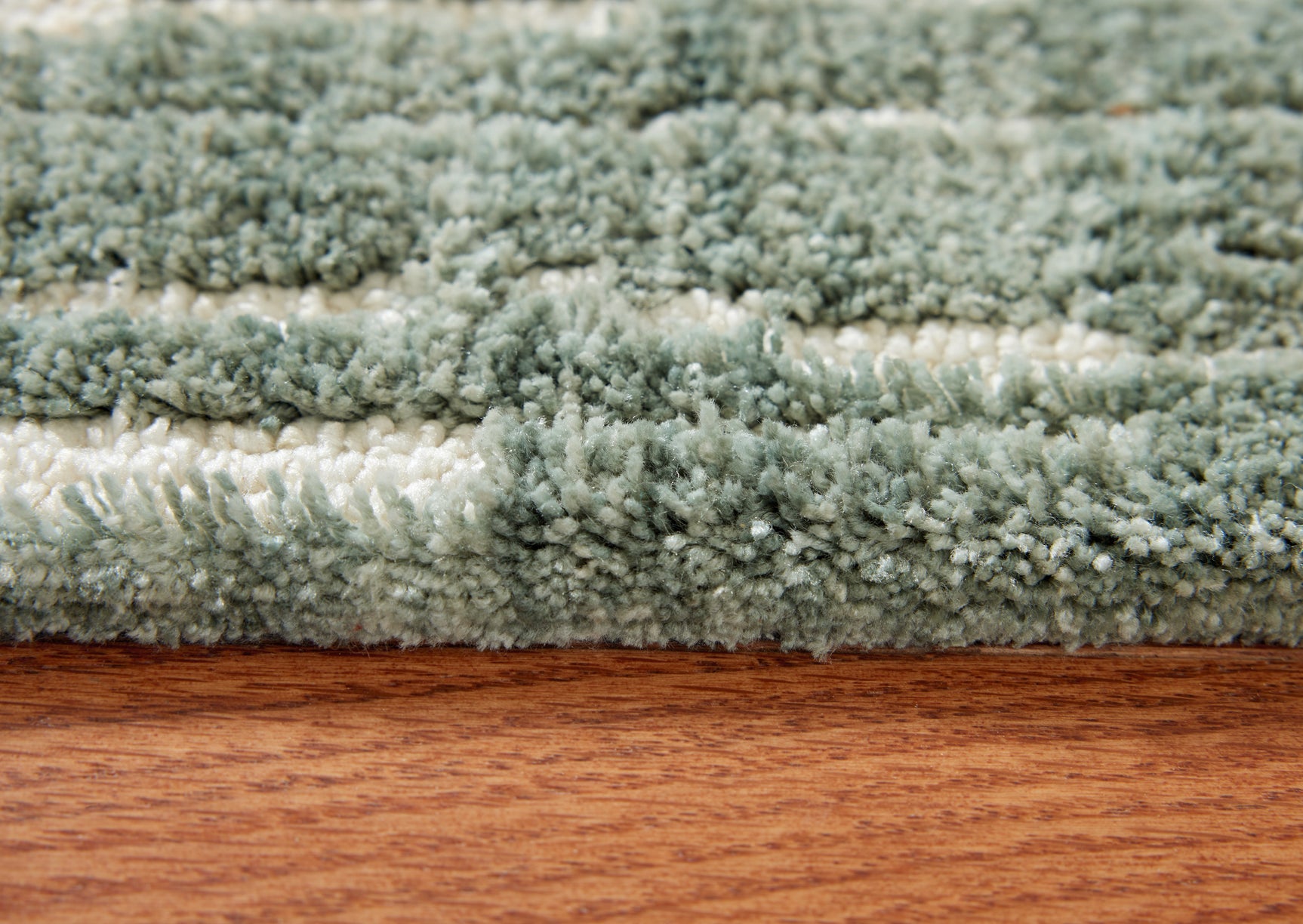 Close-up of the teal and white abstract striped pattern on the Cayworth rug