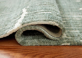 Side view of Cayworth teal white rug rolled for storage