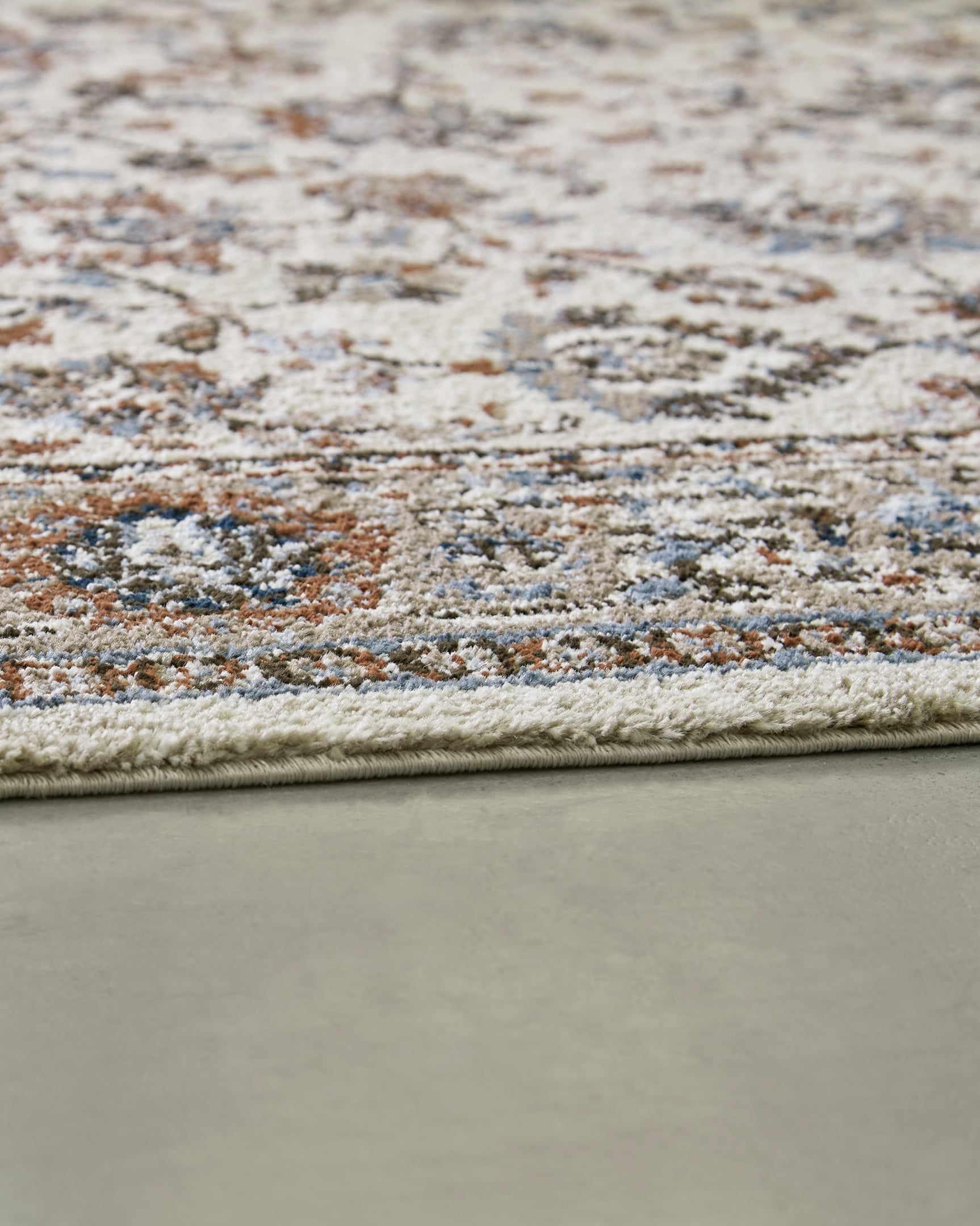 Edge detail of Beritham Medium Blue/Brown/Beige Rug rolled up