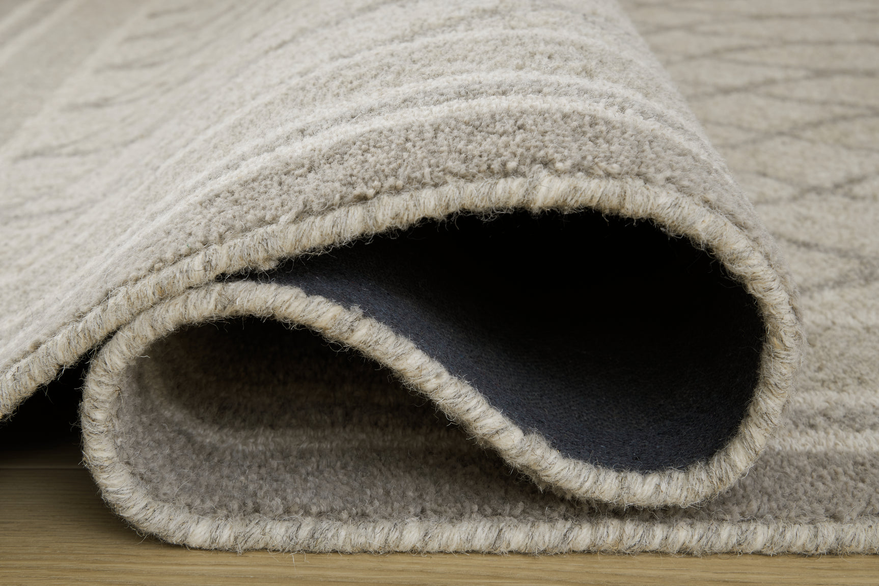 Rolled view of Wimney Gray Wool Rug highlighting fabric