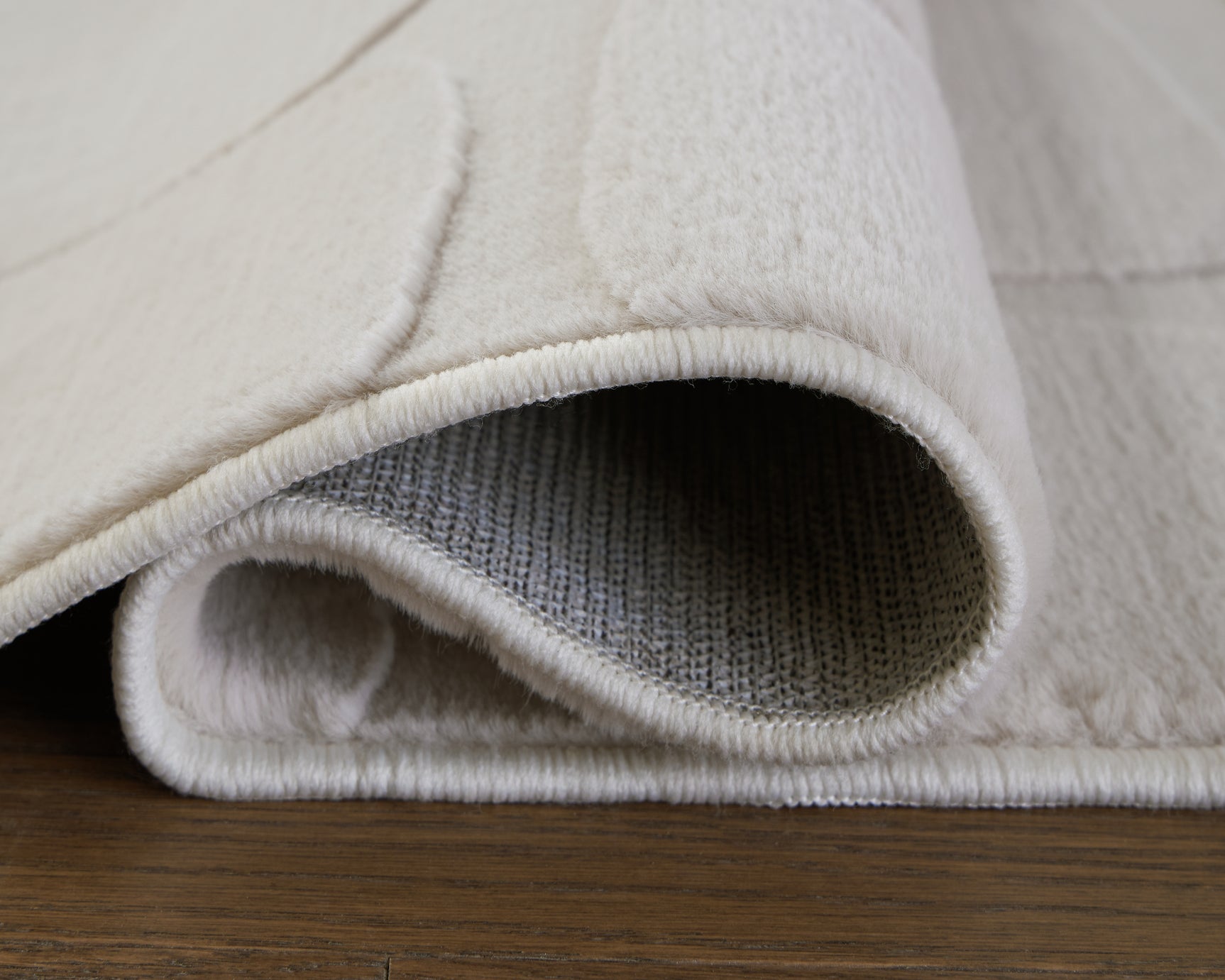 Rolled side view of Malvinsboro Sandstone Washable rug