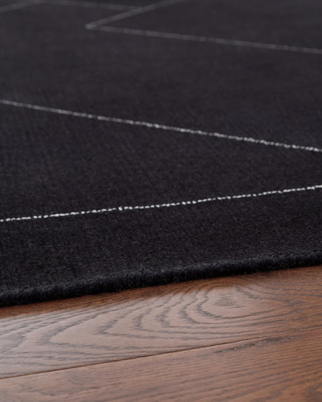 Rolled view of Marav black and white wool area rug