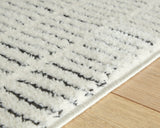 Rolled view of Turinwith ivory and black area rug edge