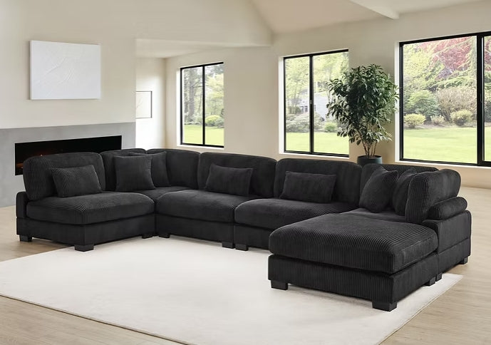 Close-up detail of soft black corduroy fabric on sectional sofa