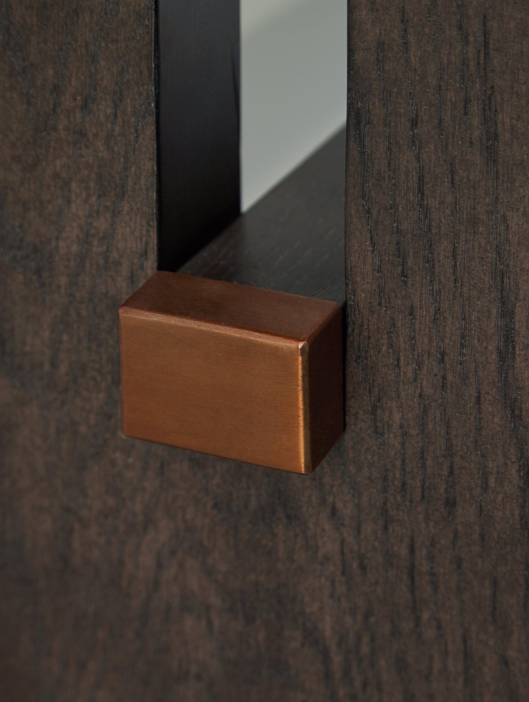 Detail of brass-tone capped stretcher on plinth base