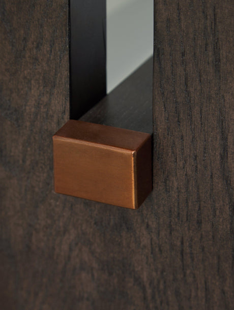 Detail of brass-tone capped stretcher on plinth base