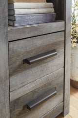 Side angle of entertainment center showing rustic oak grain and crossbuck detail
