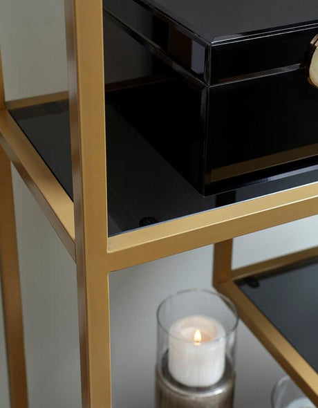 Close-up of gold metal frame and gray tinted glass shelf on Frankwell bookcase