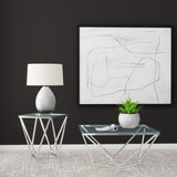 Brittania glass top end table placed next to leather sofa