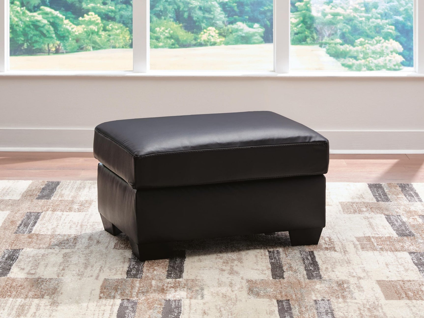 Glennbre Midnight Faux Leather Ottoman from Decor Furniture