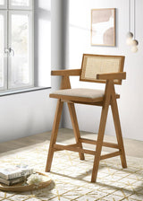Side angle of Kane light walnut bar stool with rattan back and upholstered sand seat