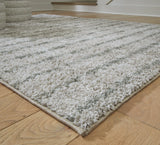 Side angle showing thickness of Laddway cream and green medium area rug