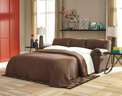 Coffee faux leather full size sleeper sofa angled view showing built-in headboard