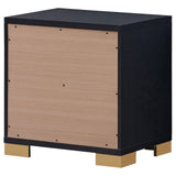 Black nightstand with geometric design and gold accents in bedroom setting