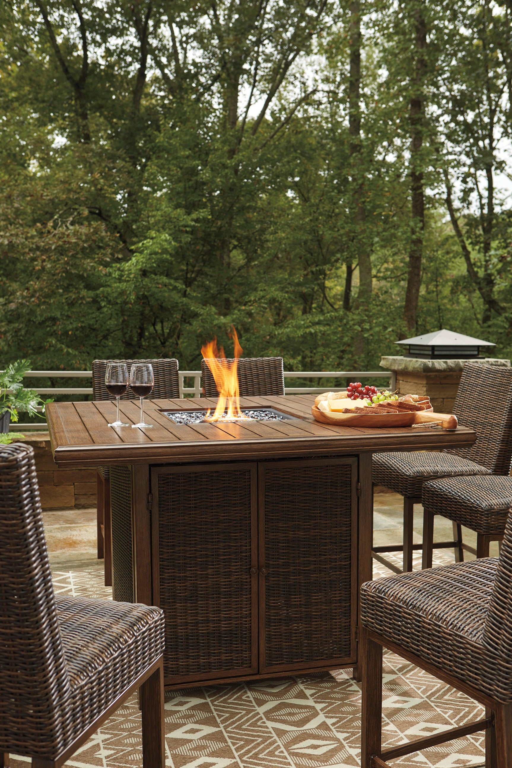 Side angle of outdoor bar table showing wood-look finish and wicker accents