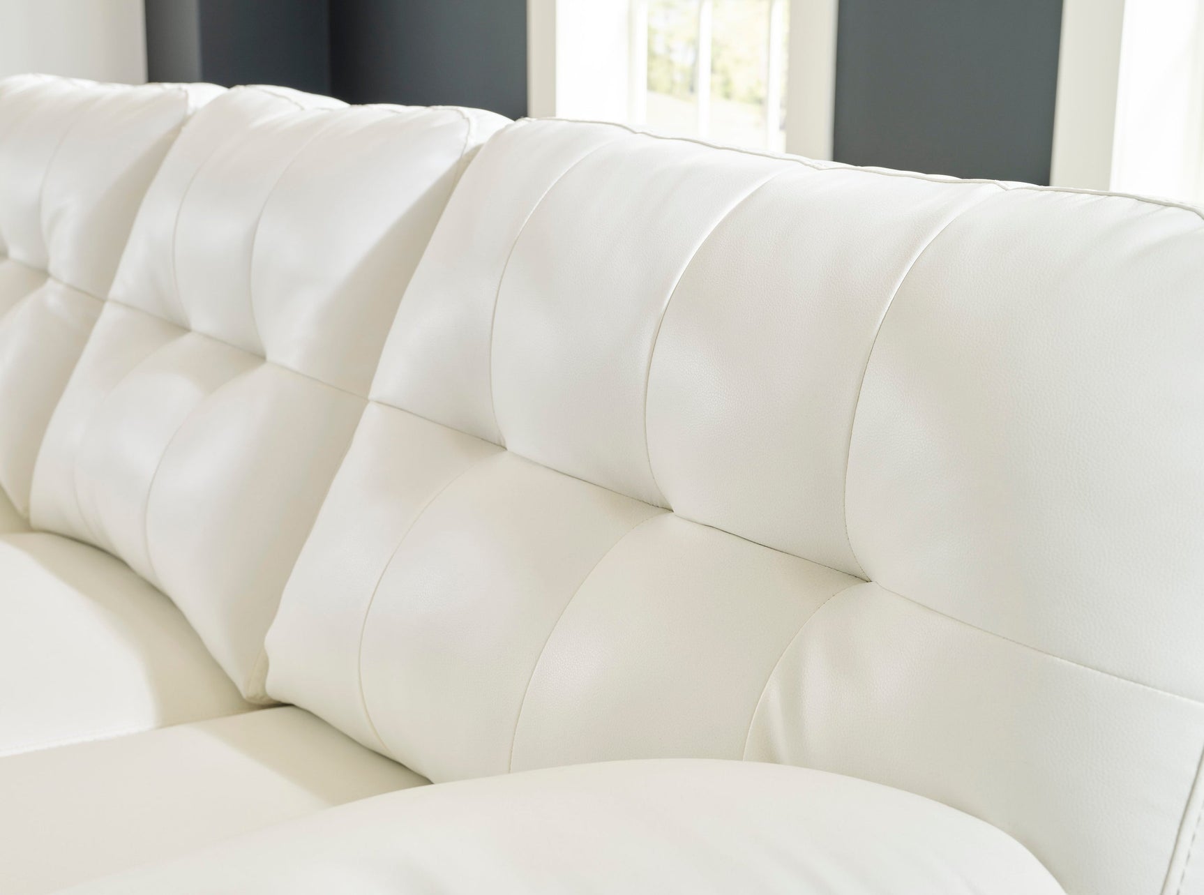 Close-up of tufted faux leather upholstery on Ashley RAF Chaise sectional