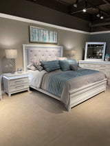Bedroom view highlighting Ser White Upholstered Tufted Panel Bedroom Set bed