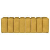 Close-up of tufted fabric seat on mustard yellow bench