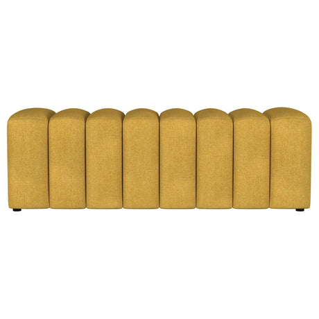 Close-up of tufted fabric seat on mustard yellow bench
