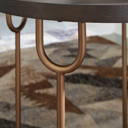 Close-up of metal tubular legs with antiqued goldtone finish on Hugh round cocktail table